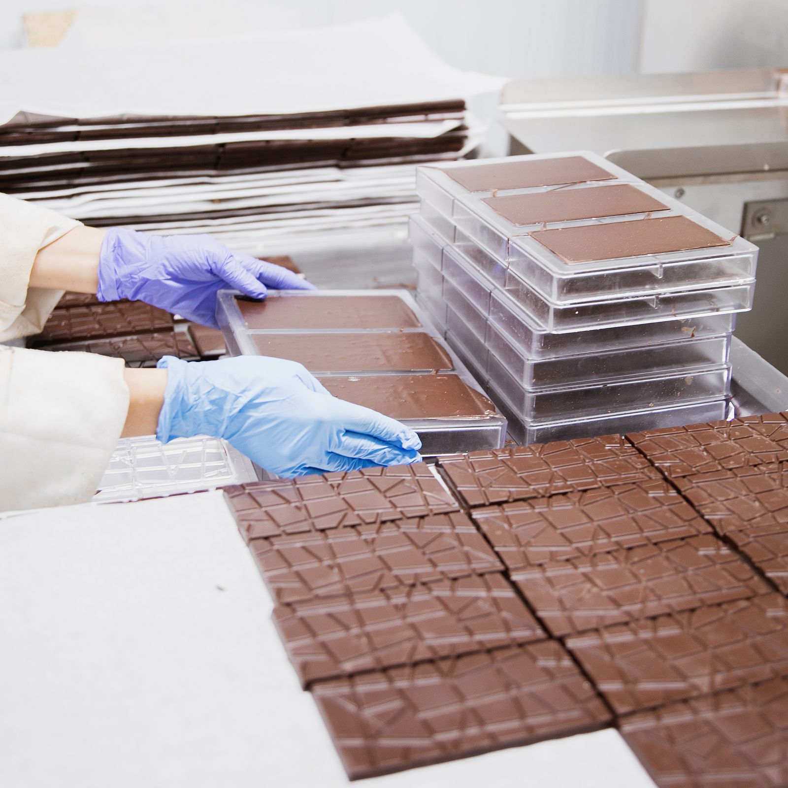 Manos desmoldando tabletas de chocolate